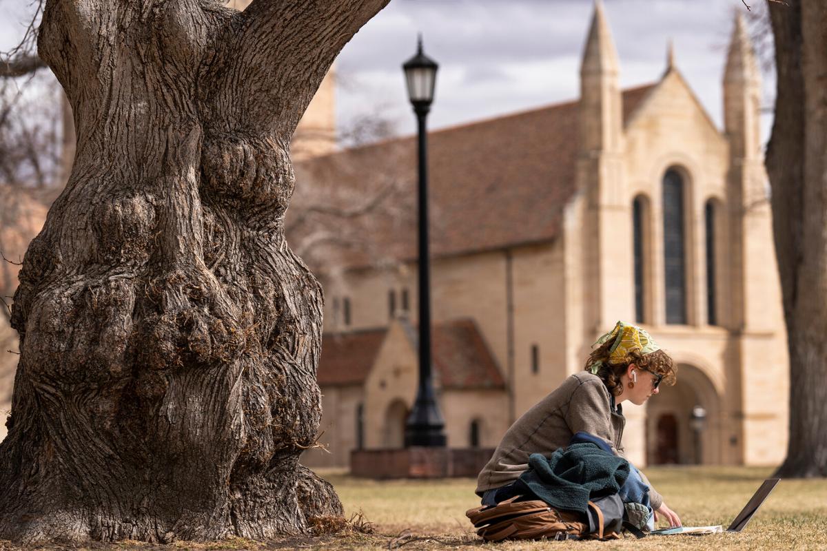 Luca Keon ’25 researches in Tava Quad with Shove Memorial Chapel in the background during a warm winter day in Tava Quad on 3/15/23. Photo by Lonnie Timmons III / Colorado College.